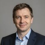 Портрет уверенного российского бизнесмена с дружелюбным взглядом на размытом нейтральном фоне в студии
