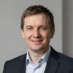 Портрет уверенного российского бизнесмена с дружелюбным взглядом на нейтральном размытом фоне студии